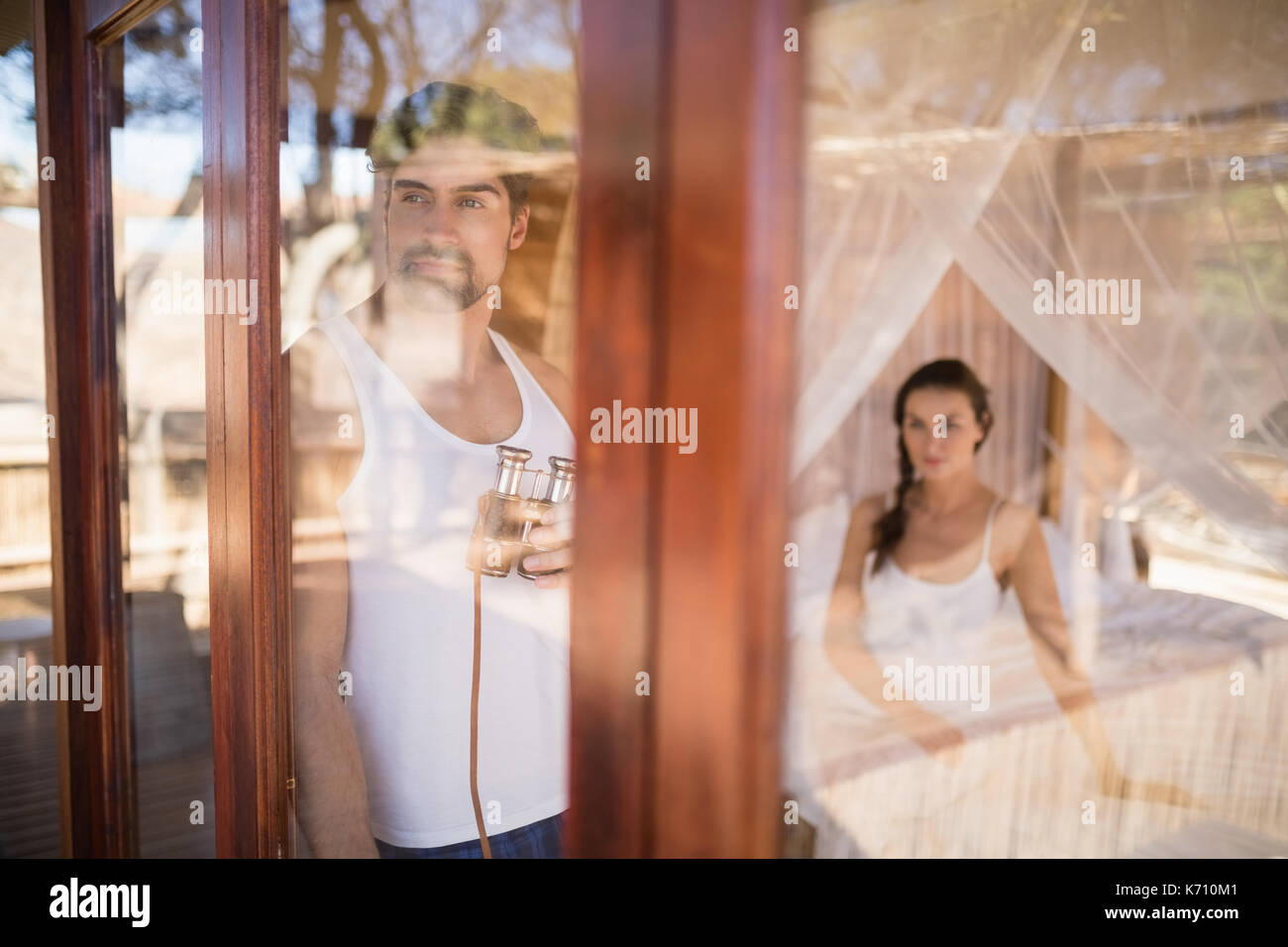 Thoughtful man looking through window during safari vacation Stock Photo