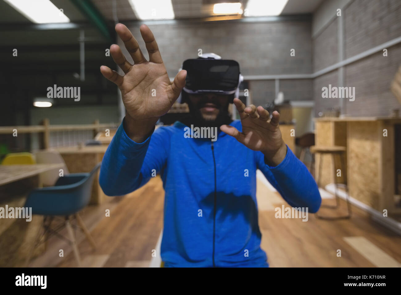 Man looking through virtual reality simulator while sitting in cafeteria Stock Photo