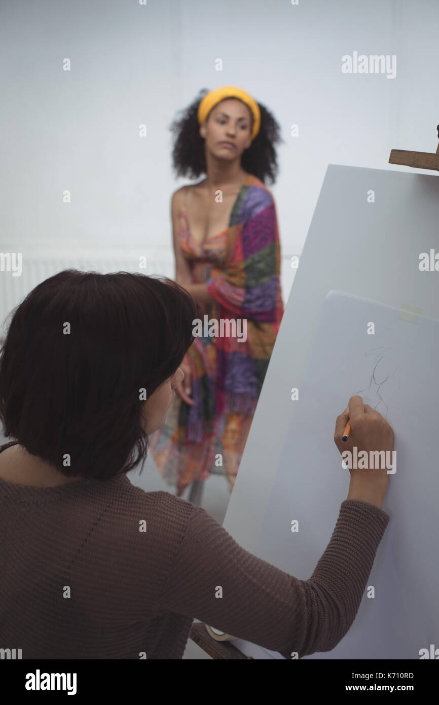 Female artist drawing a sketch of woman on canvas in art studio Stock ...