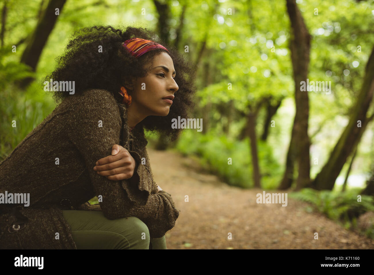 Side view of thoughtful young woman looking away at forest Stock Photo