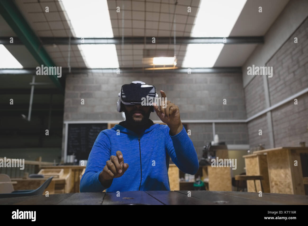 Man looking through virtual reality simulator while sitting in cafe Stock Photo