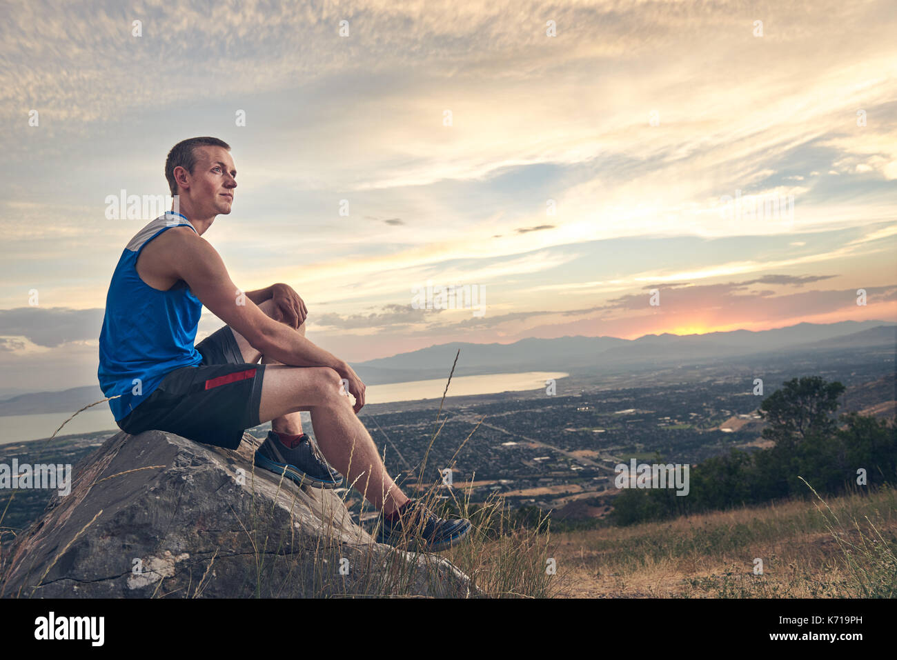 Resting On Rocks Man resting on rock after a run during sunset Stock Photo - Alamy