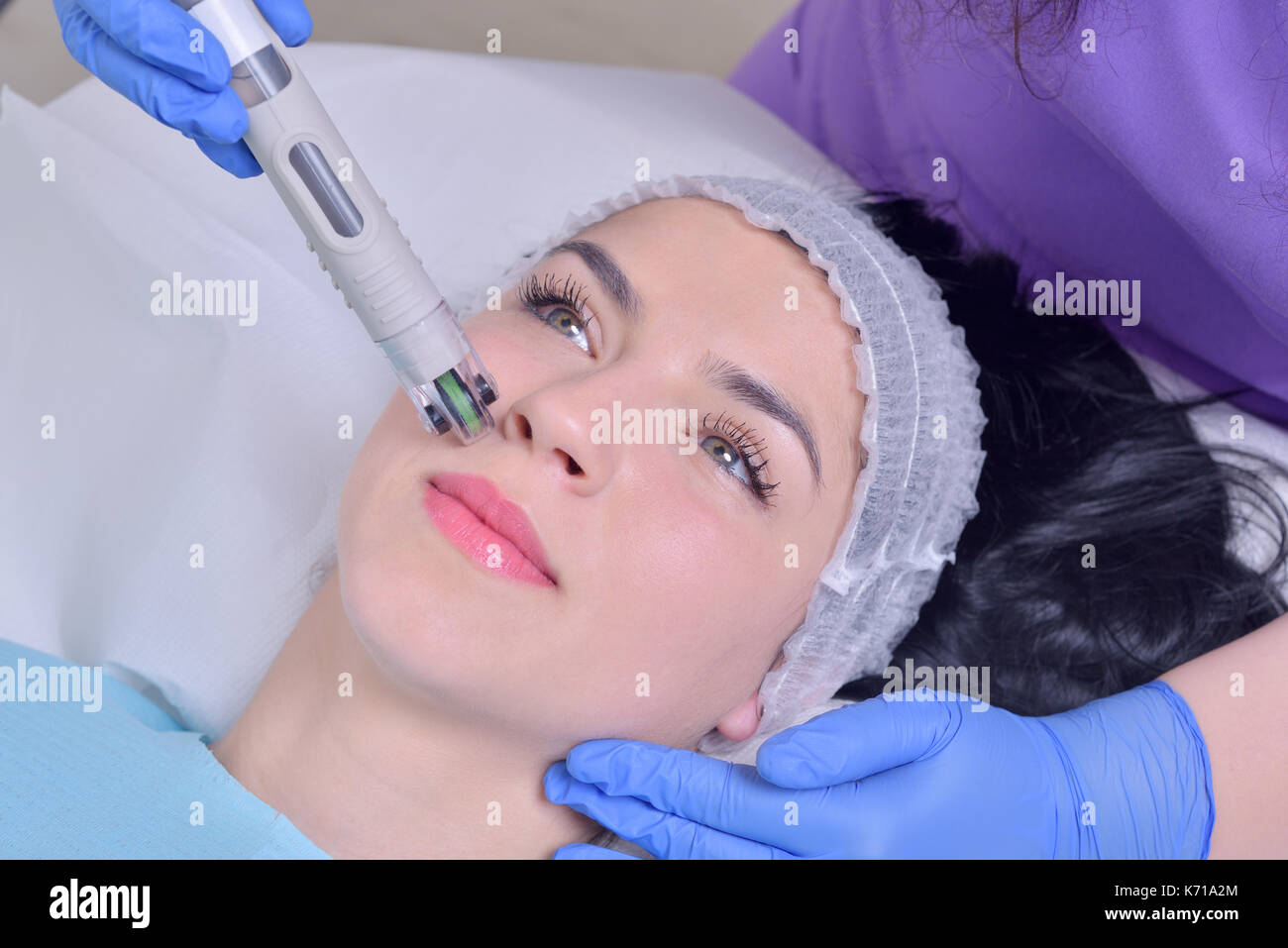 Young beautiful woman gets professional rejuvenation facial skin treatment in a professional beauty clinic Stock Photo