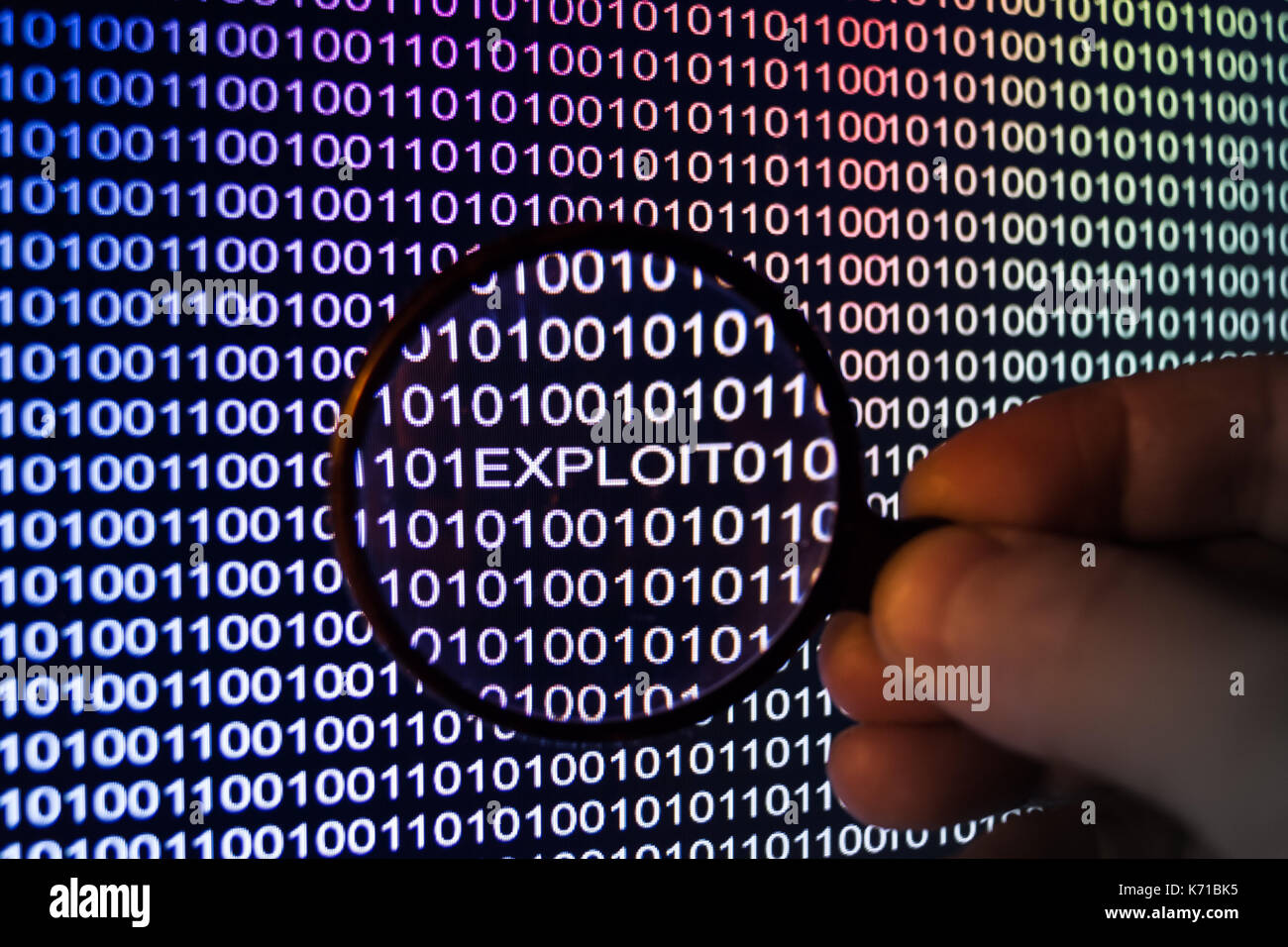 Binary code, Password security, hand holding magnifying glass showing exploit Stock Photo