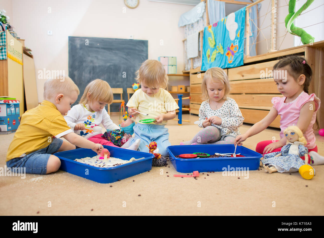 Children improving hands motor skills with rice and beans Stock Photo