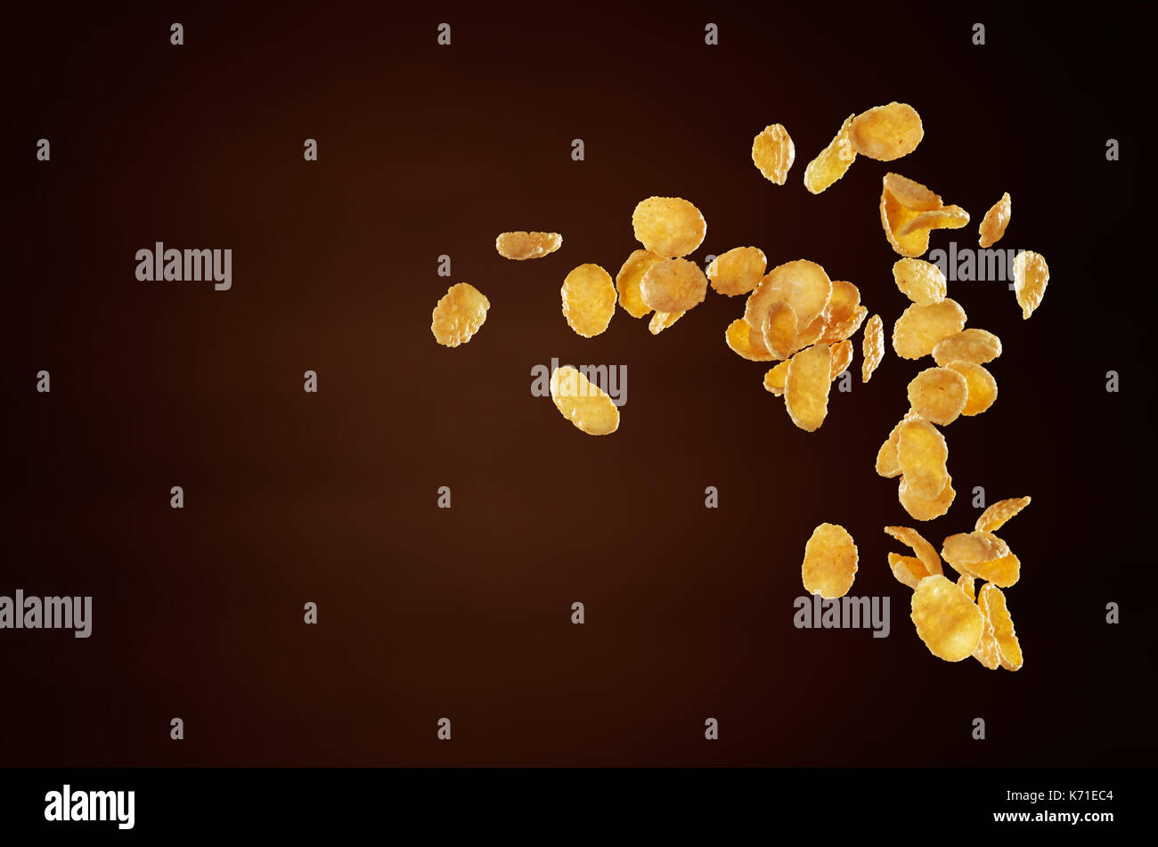 corn flakes flying isolated on brown background Stock Photo