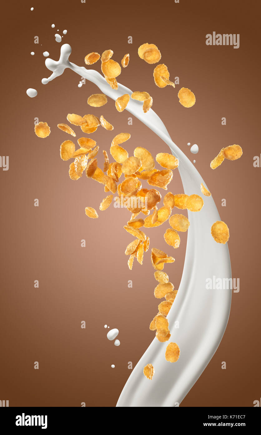 corn flakes with milk splashing against brown background Stock Photo