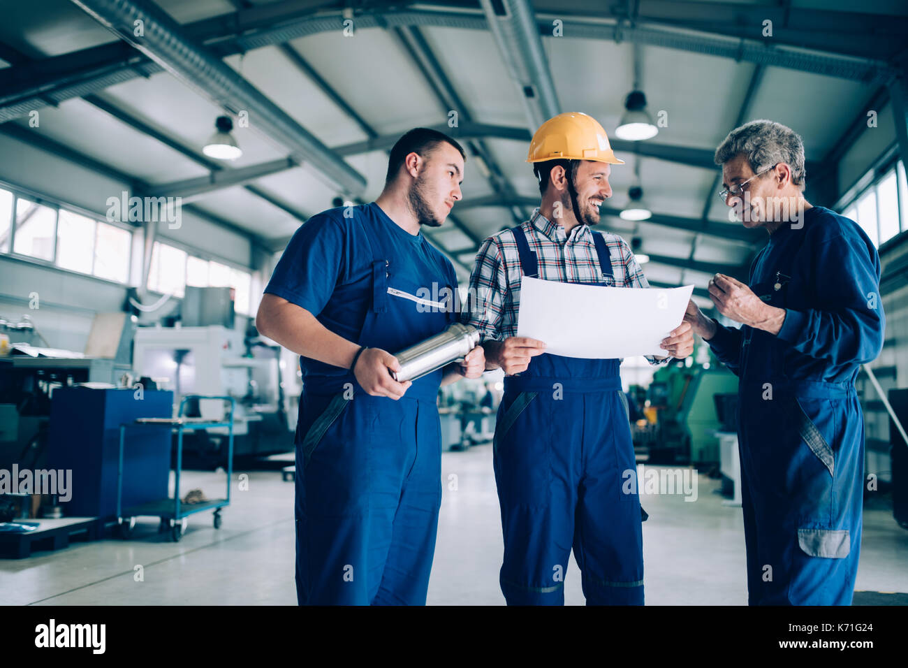 Engineer Teaching Apprentices To Use Computerized cnc metal processing machines Stock Photo