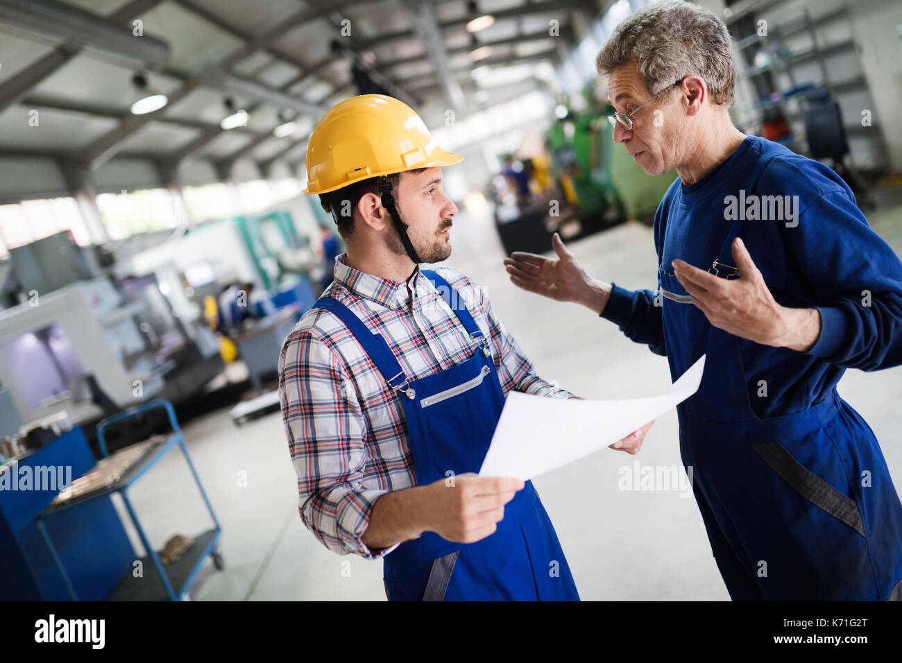 Engineer Teaching Apprentices To Use Computerized cnc metal processing machines Stock Photo