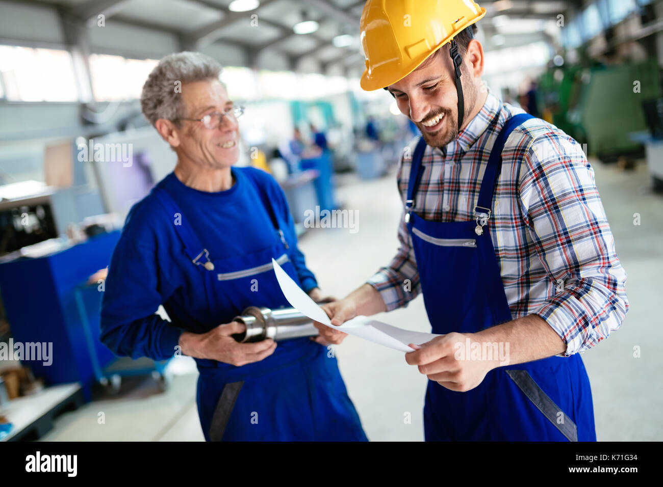 Engineer Teaching Apprentices To Use Computerized cnc metal processing machines Stock Photo