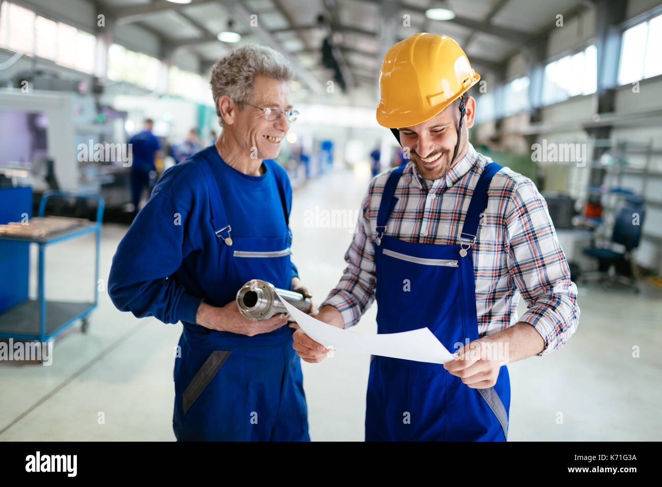 Engineer Teaching Apprentices To Use Computerized cnc metal processing machines Stock Photo
