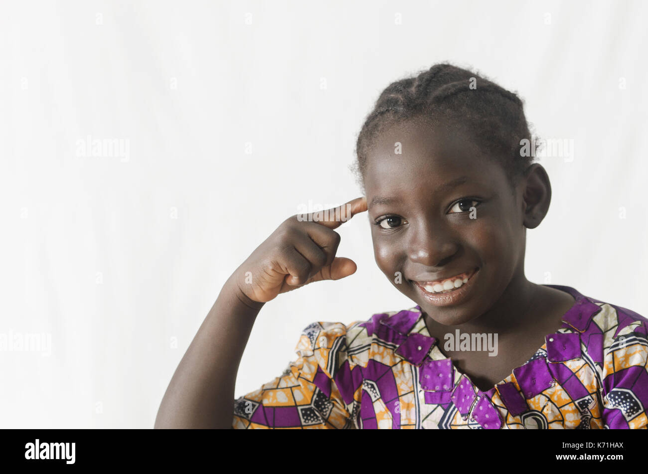 Gorgeous African girl pointing finger at her head, isolated on white Stock Photo