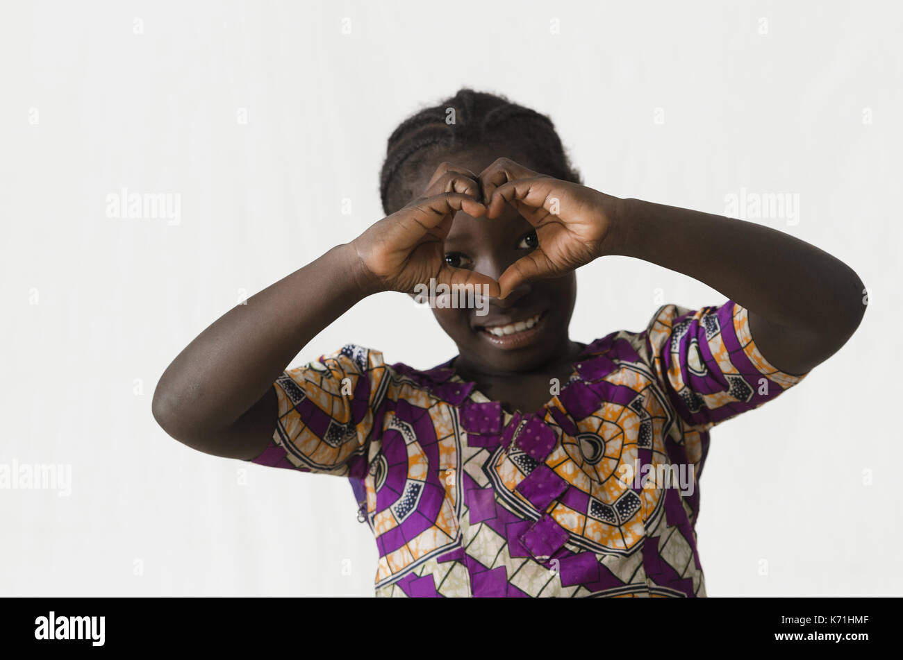 Gorgeous African girl making a heart shape with her fingers and hands, isolated on white Stock Photo
