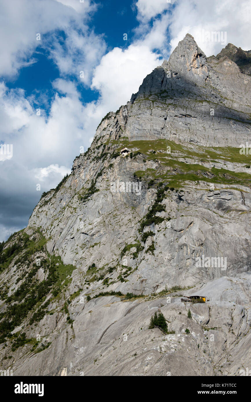 Two huts nestled in the rock face of the Wetterhorn above Schwarze Lütschine, Grindelwald, Switzerland Stock Photo