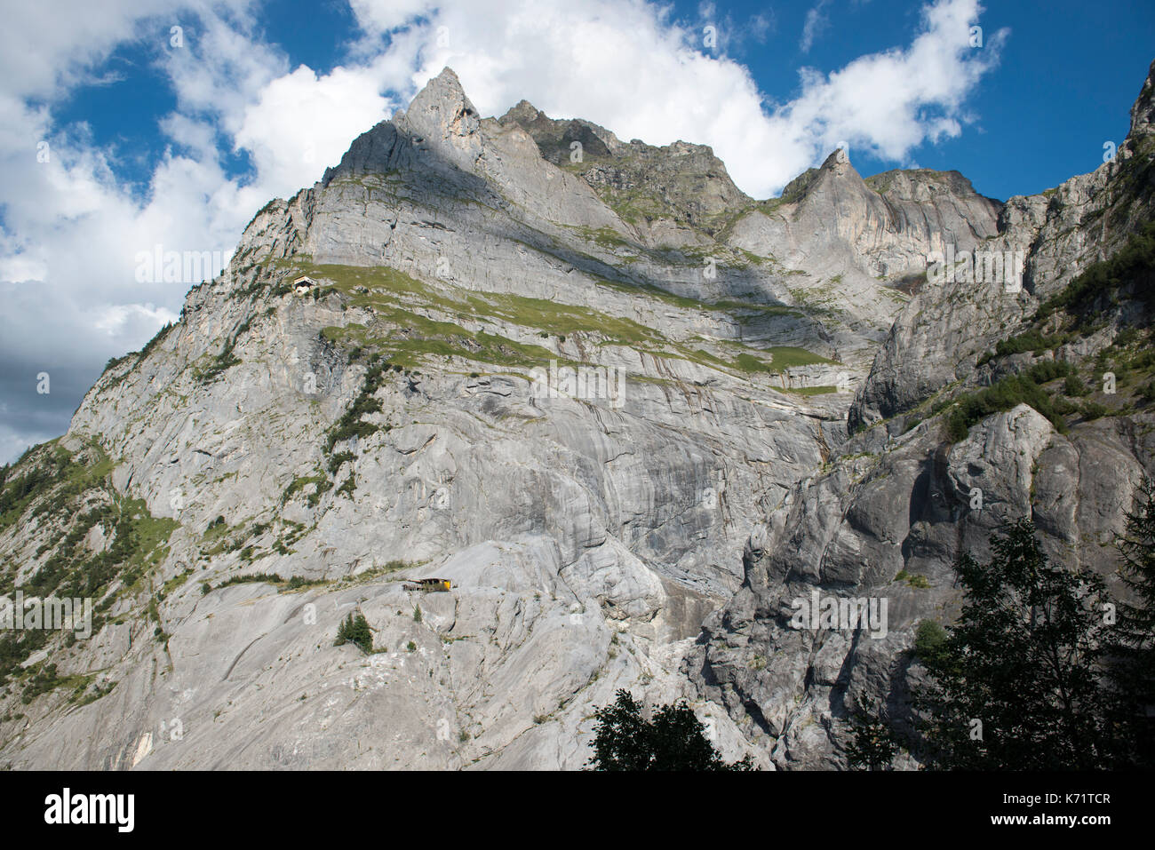 Two huts nestled in the rock face of the Wetterhorn above Schwarze Lütschine, Grindelwald, Switzerland Stock Photo
