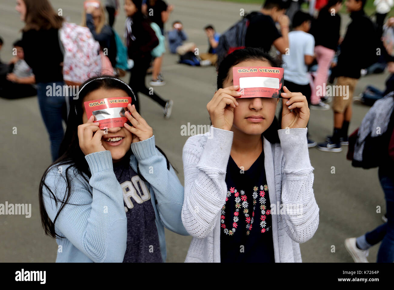 Napa, CA, USA. 21st Aug, 2017. Redwood Middle School students Andreina Verduzco, left, and Carolina Torres, both 12, try and catch a glimpse of Monday's solar eclipse. Heavy clouds kept the sun mostly hidden in Napa. Credit: Napa Valley Register/ZUMA Wire/Alamy Live News Stock Photo