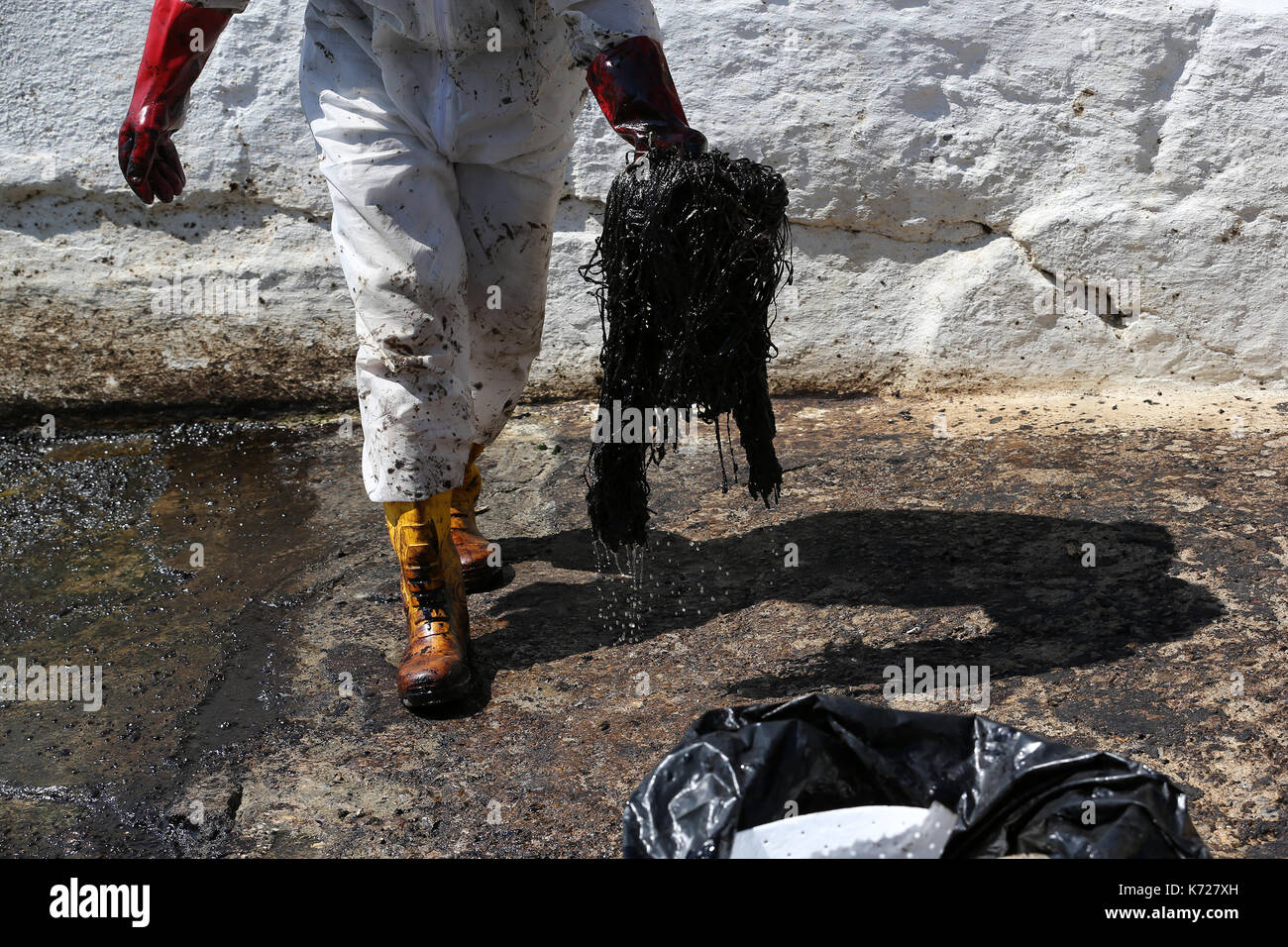 (170914) -- ATHENS, Sept. 14, 2017 (Xinhua) -- A specialized crew member takes part in an operation to clean the oil spill from the shores of Piraeus, a southeast suburb of Athens, capital of Greece, on Sept. 14, 2017. A major clean-up operation which was underway on Thursday to address an oil spill that has spread across a large area of the Saronic Gulf will last for about three weeks, Greek Shipping Minister Panagiotis Kouroumblis told a press briefing. The environmental crisis broke out on Sunday after the sinking of small tanker 'Agia Zoni II' carrying about 2,500 tons of oil, which was an Stock Photo