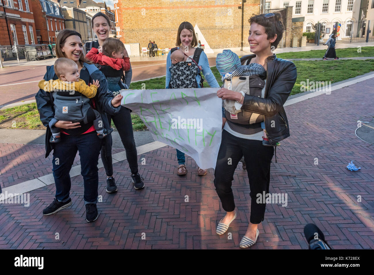 London, UK. 14th September 2017. Mothers carry young children at Windrush Square before the 'Stop Killing Londoners' protest against London's excessive air pollution, due mainly to traffic. They walked to the crossing at Brixton Underground station, walking onto the pedestrian crossing and stopping traffic. The air on the Brixton Road breaches the annual pollution limit in only 5 days, roughly 70 times the limit per year. Toxic air pollution results in 10,000 premature deaths in London each year and is particularly harmful to the elderly and the very young. To cut the disruption to traffic the Stock Photo