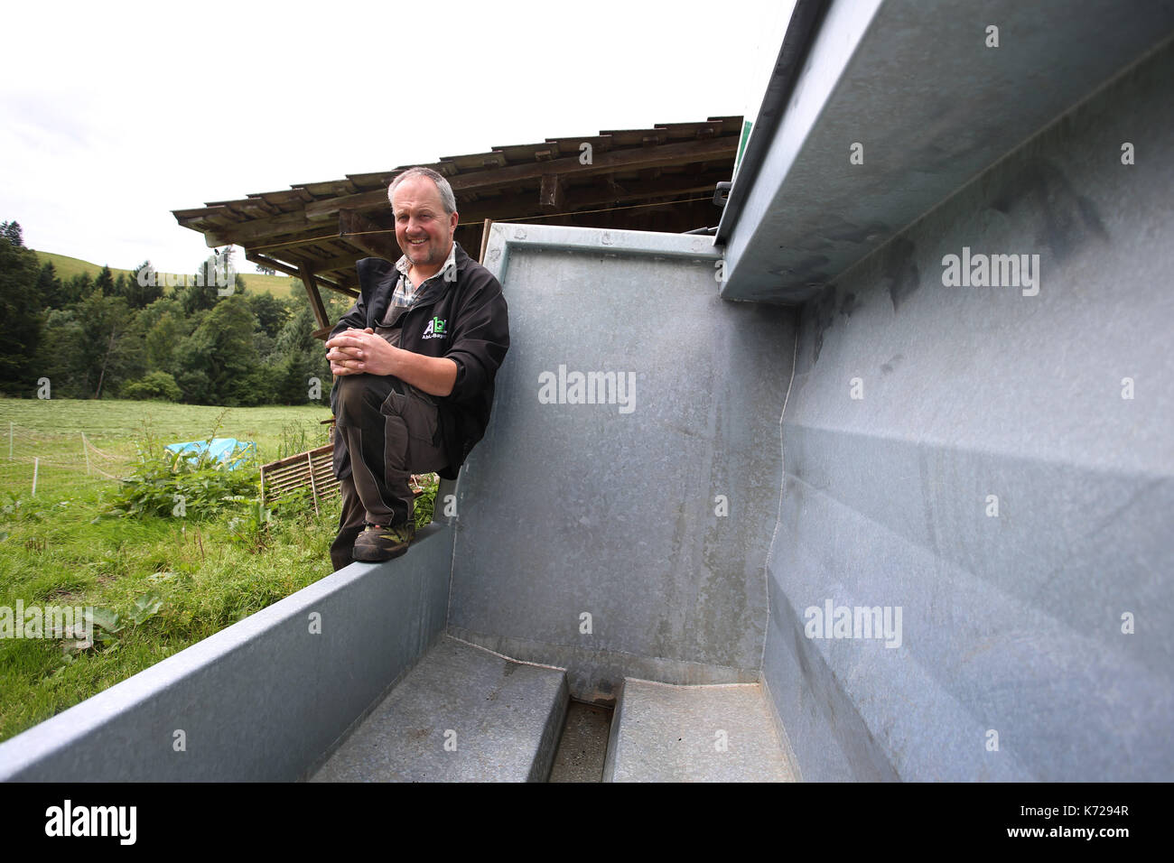 Missen, Germany. 21st Aug, 2017. Farmer Herbert Siegel sits on his mobile slaughtering station (German: 'Mobile Schlacht Box' or 'mobile slaugher box') in Missen, Germany, 21 August 2017. The station allows Siegel to slaughter his cows in the meadows in which they graze, thus sparing them the stressful journey to the slaugher house. Siegel is one of the few farmers to use such a device in Germany. Photo: Karl-Josef Hildenbrand/dpa/Alamy Live News Stock Photo