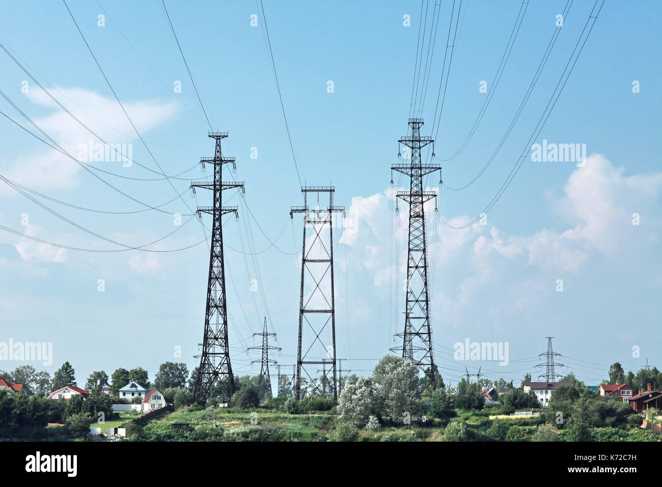 Power lines and electricity pylon against blue sky Stock Photo - Alamy