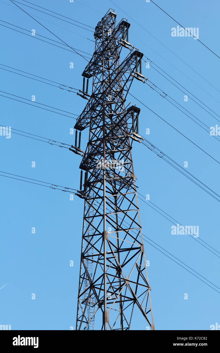 Power lines and electricity pylon against blue sky Stock Photo - Alamy
