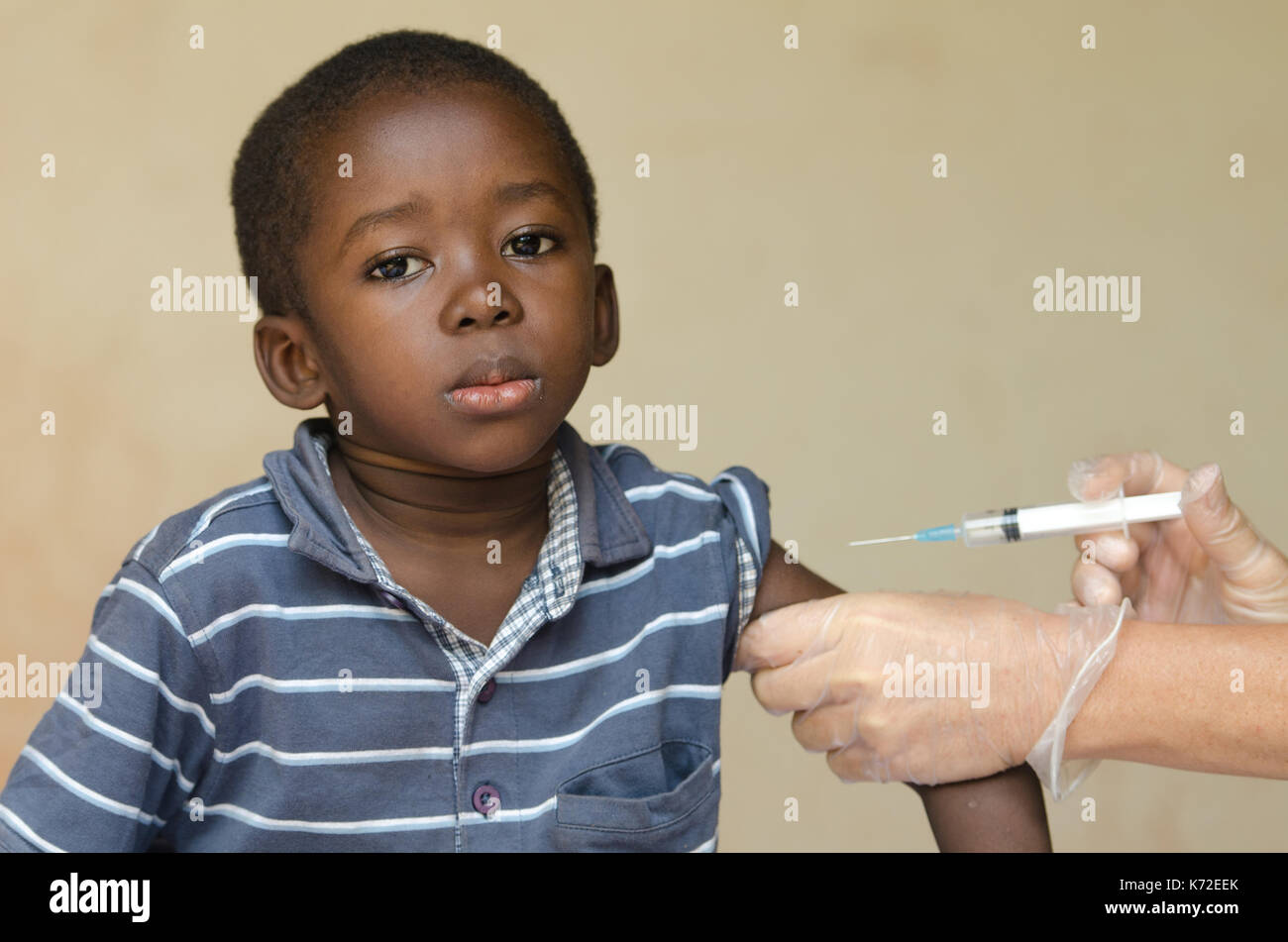 White doctor giving black African boy a needle injection as a vaccination Stock Photo