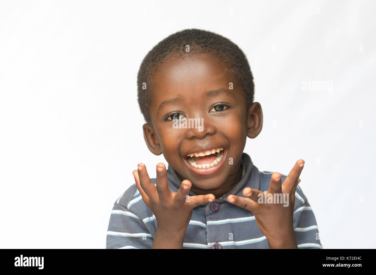 Surprised little African boy excited about getting a present isolated on white Stock Photo