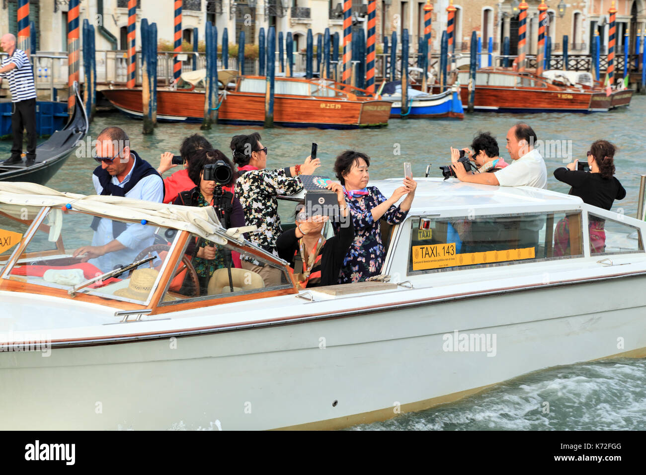 Chinese tourists on a water taxi tour in Venice. Stock Photo