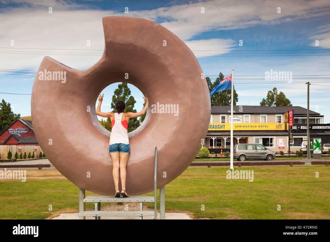 New Zealand, South Island, Selwyn District, Springfield, large donut sculpture with young woman Stock Photo