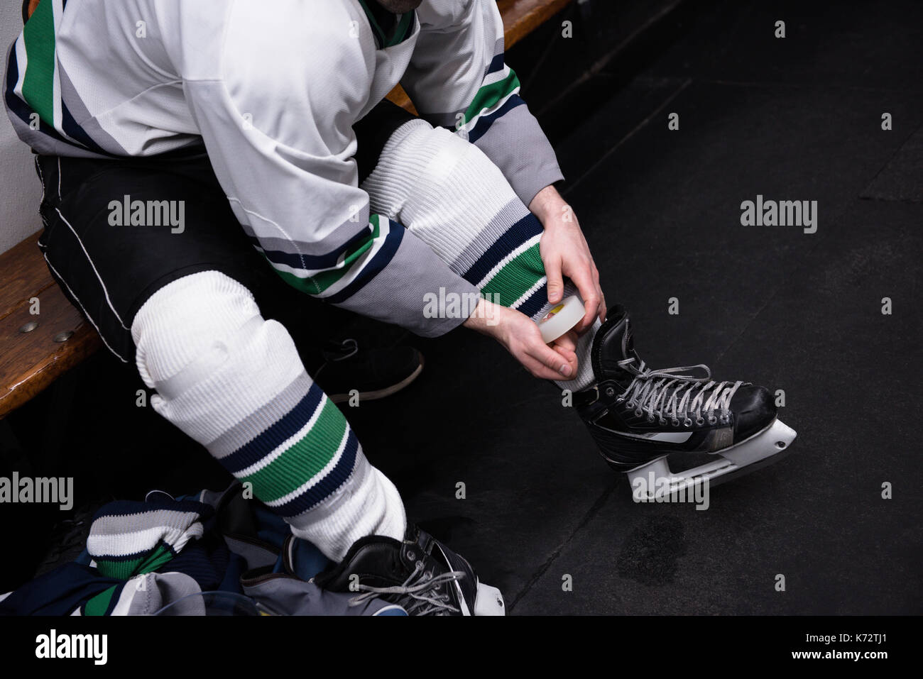 Low section of male ice hockey player wearing skate in dressing room Stock Photo Alamy