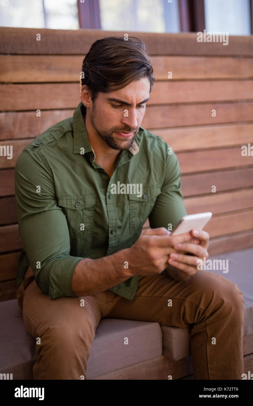 Young man using mobile phone in cottage Stock Photo
