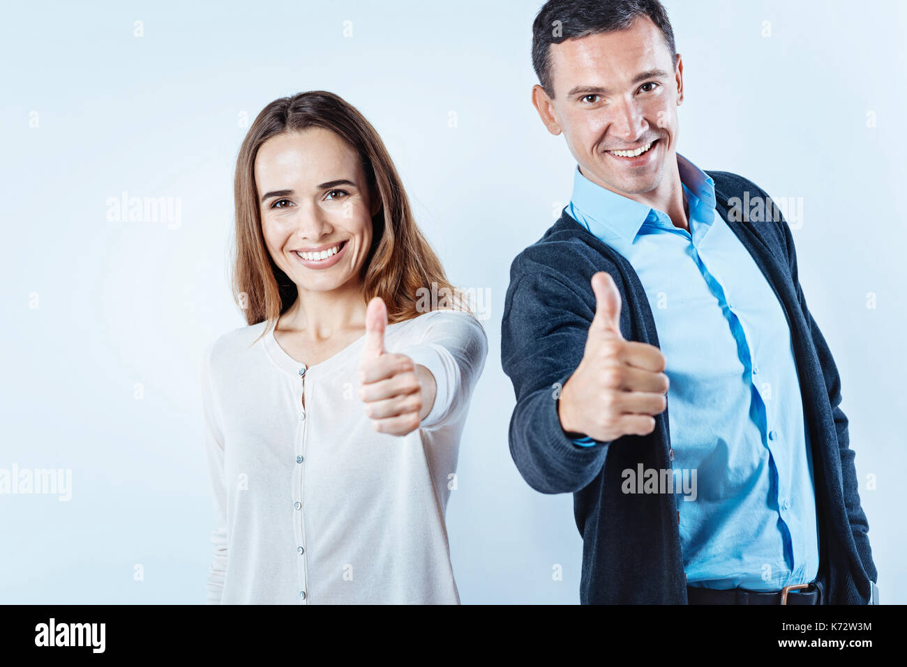 Joyful people thumbing up into camera Stock Photo - Alamy