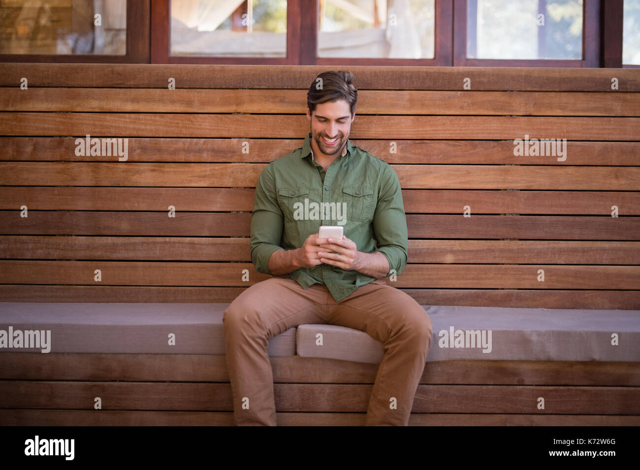 Happy man using mobile phone in cottage Stock Photo