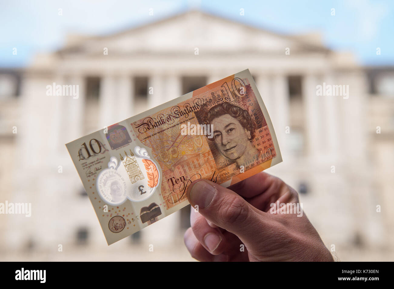 A man holds a new ten pound note featuring Jane Austen outside the Bank of England in London. Stock Photo