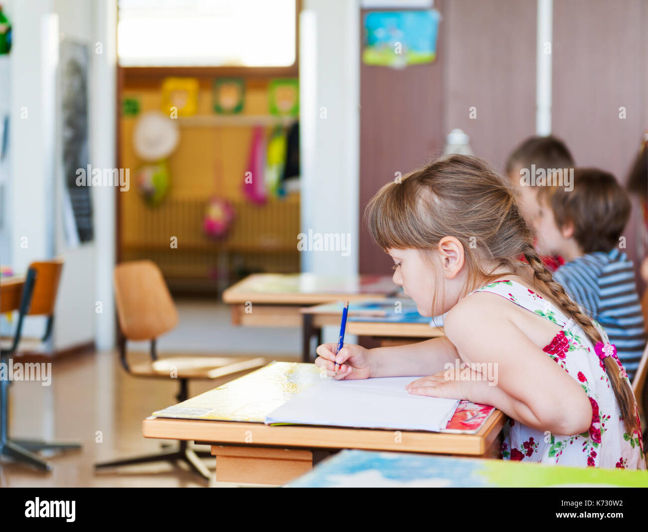 Cute little girl working in a classroom Stock Photo - Alamy