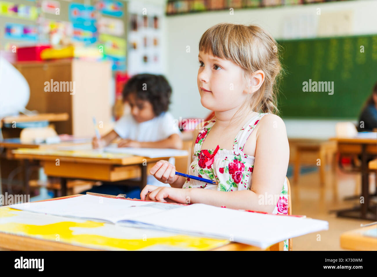 Cute little girl working in a classroom Stock Photo - Alamy