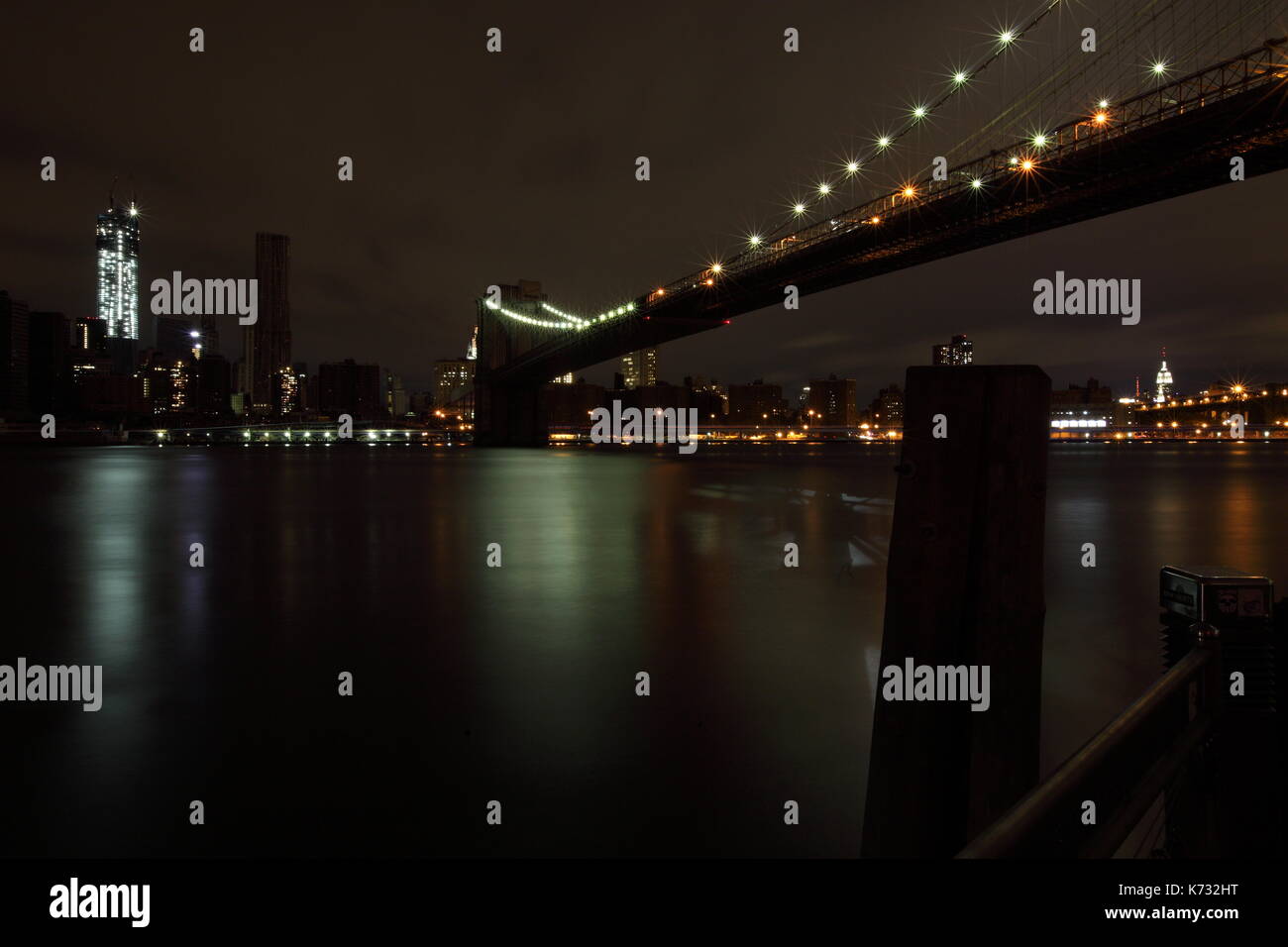 The Brooklyn bridge as seen against a dark lower Manhattan after