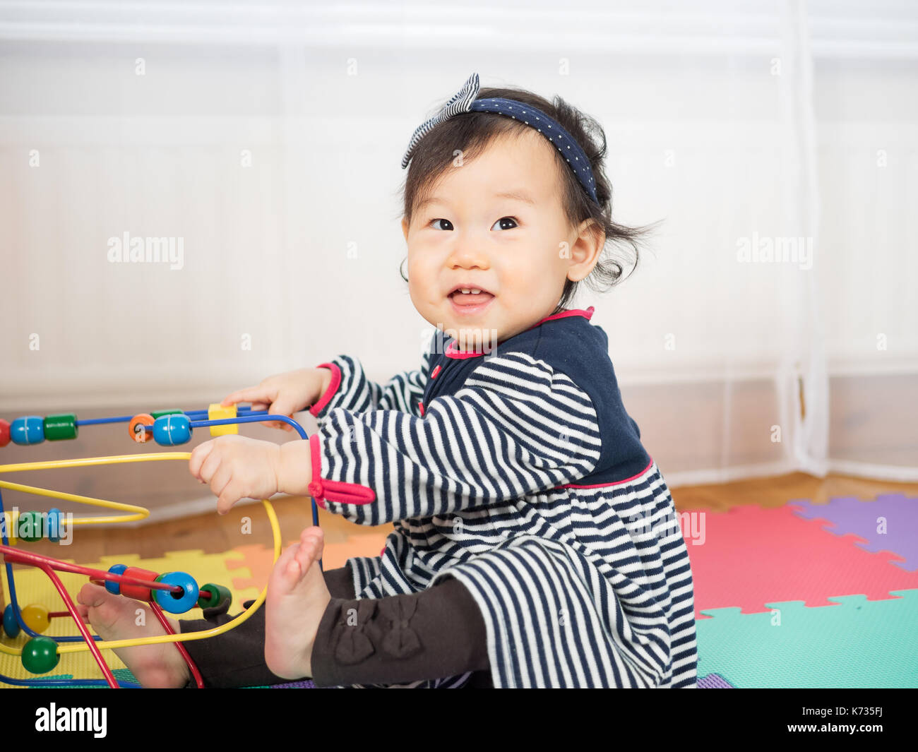 baby girl playing toy at home Stock Photo - Alamy