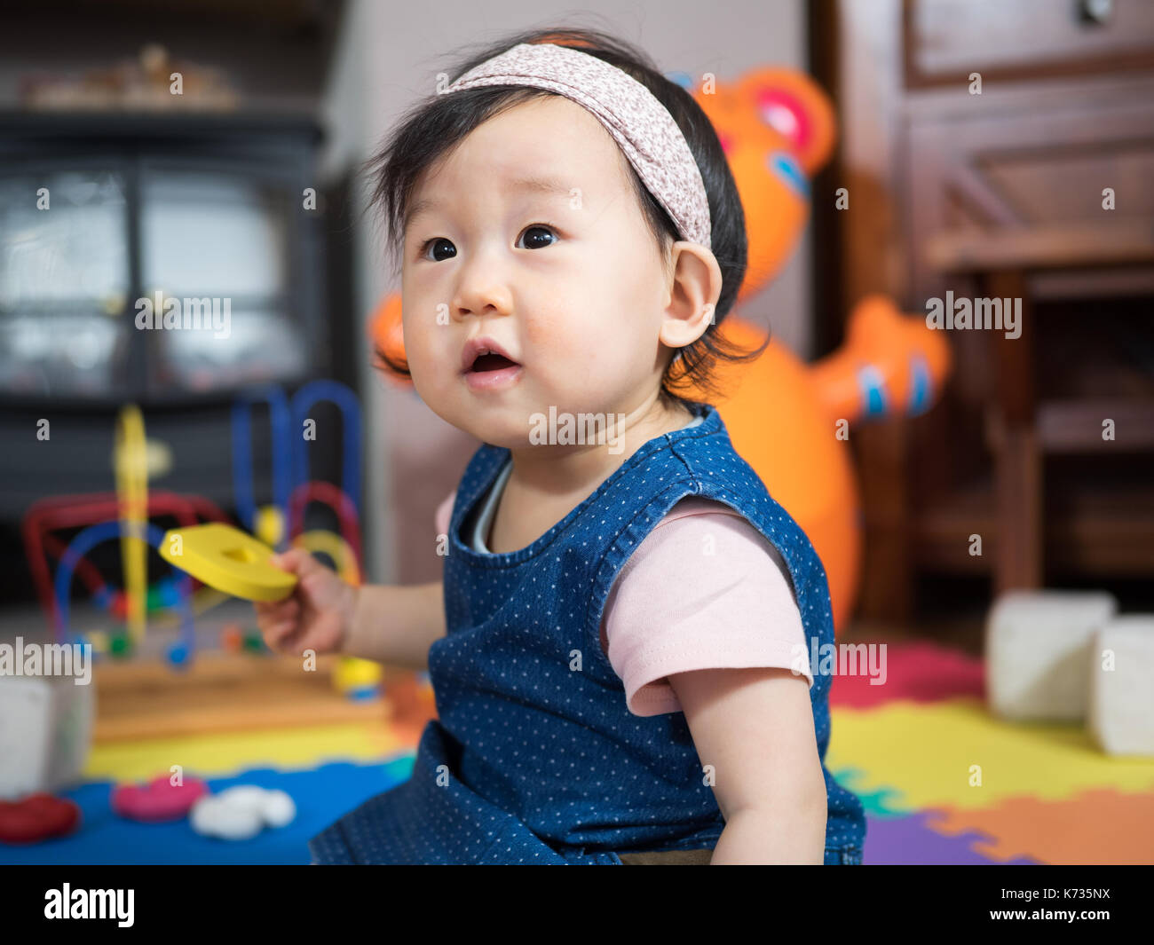 baby girl playing toy at home Stock Photo - Alamy