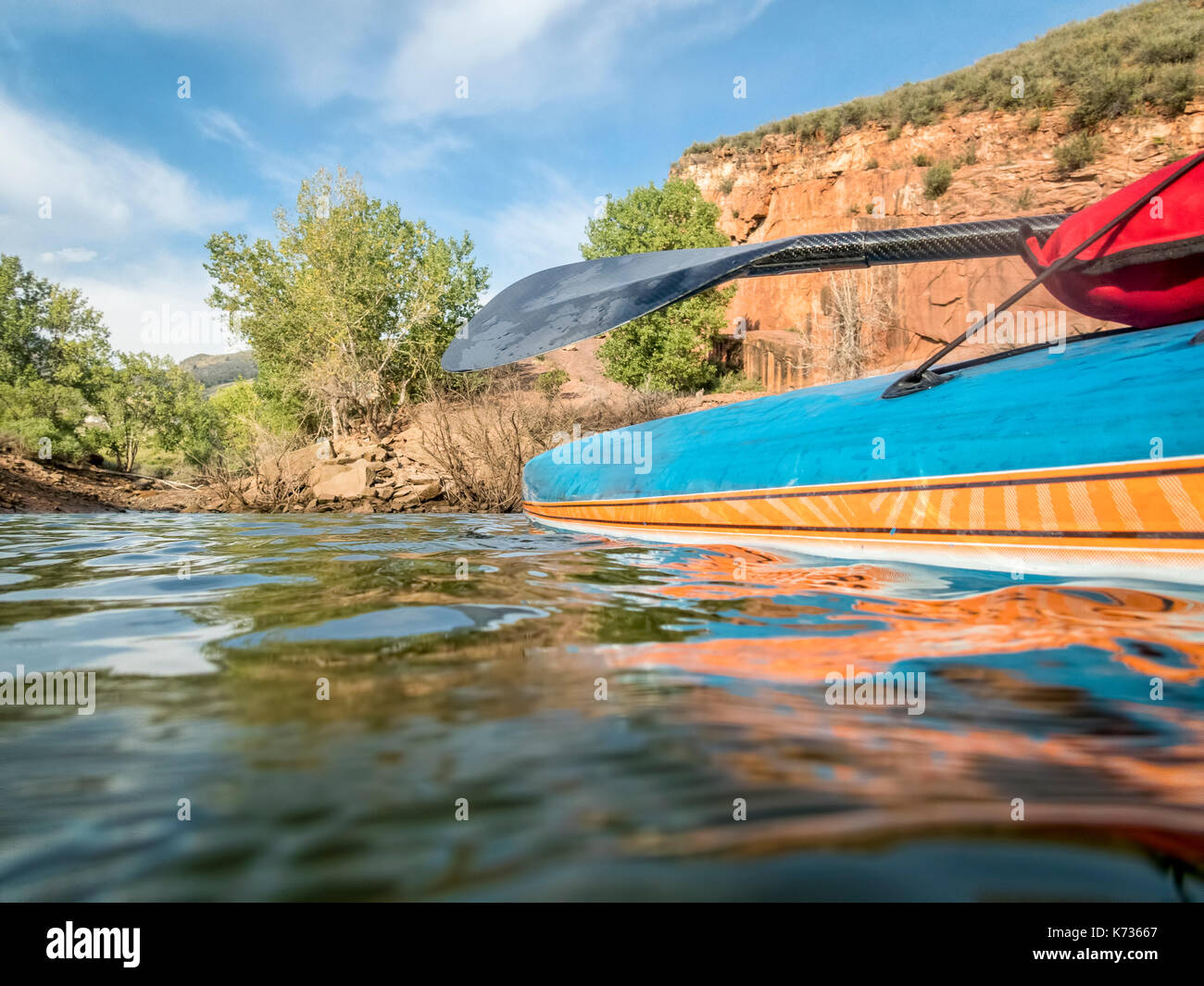Stand up paddleboard with a carbon fiber paddle low angle view on