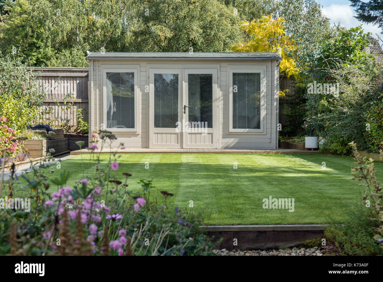 A modern summerhouse / shed in a very well manicured domestic garden Stock Photo