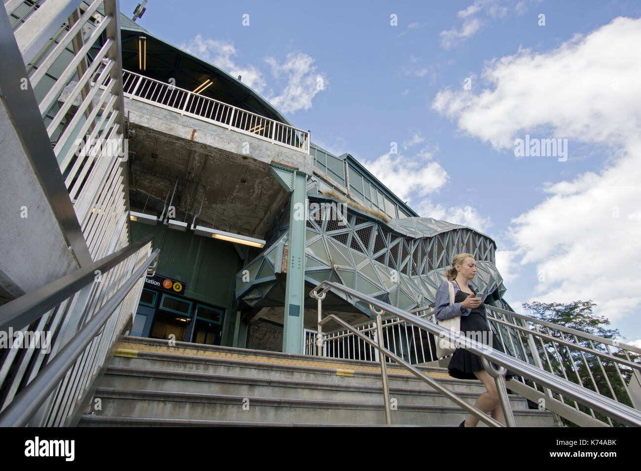A commuter descending the staircase of the West 8 Street elevated subway station in Coney Island, Brooklyn, New York City. Stock Photo