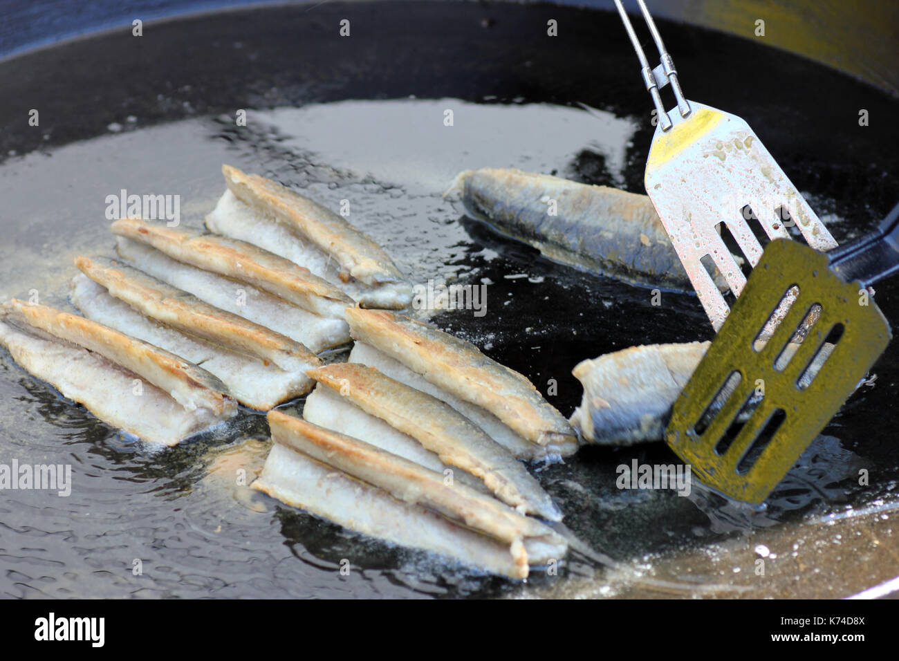Bratheringe frisch zubereitet in öl schwimmend, Fried herring prepared fresh floating in oil Stock Photo