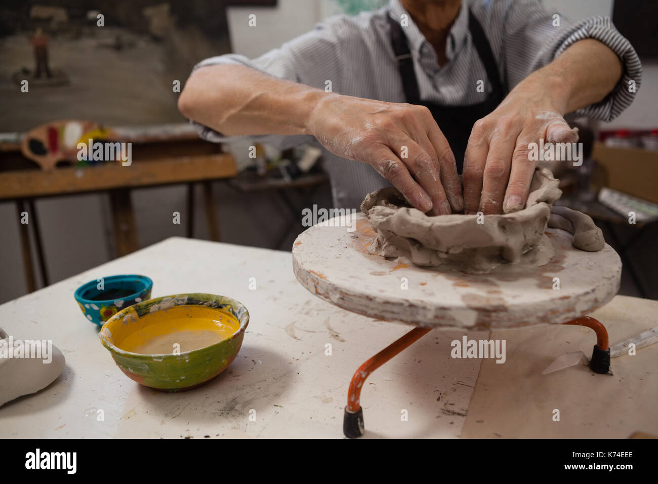 Mid-section of senior man molding clay in drawing class Stock Photo