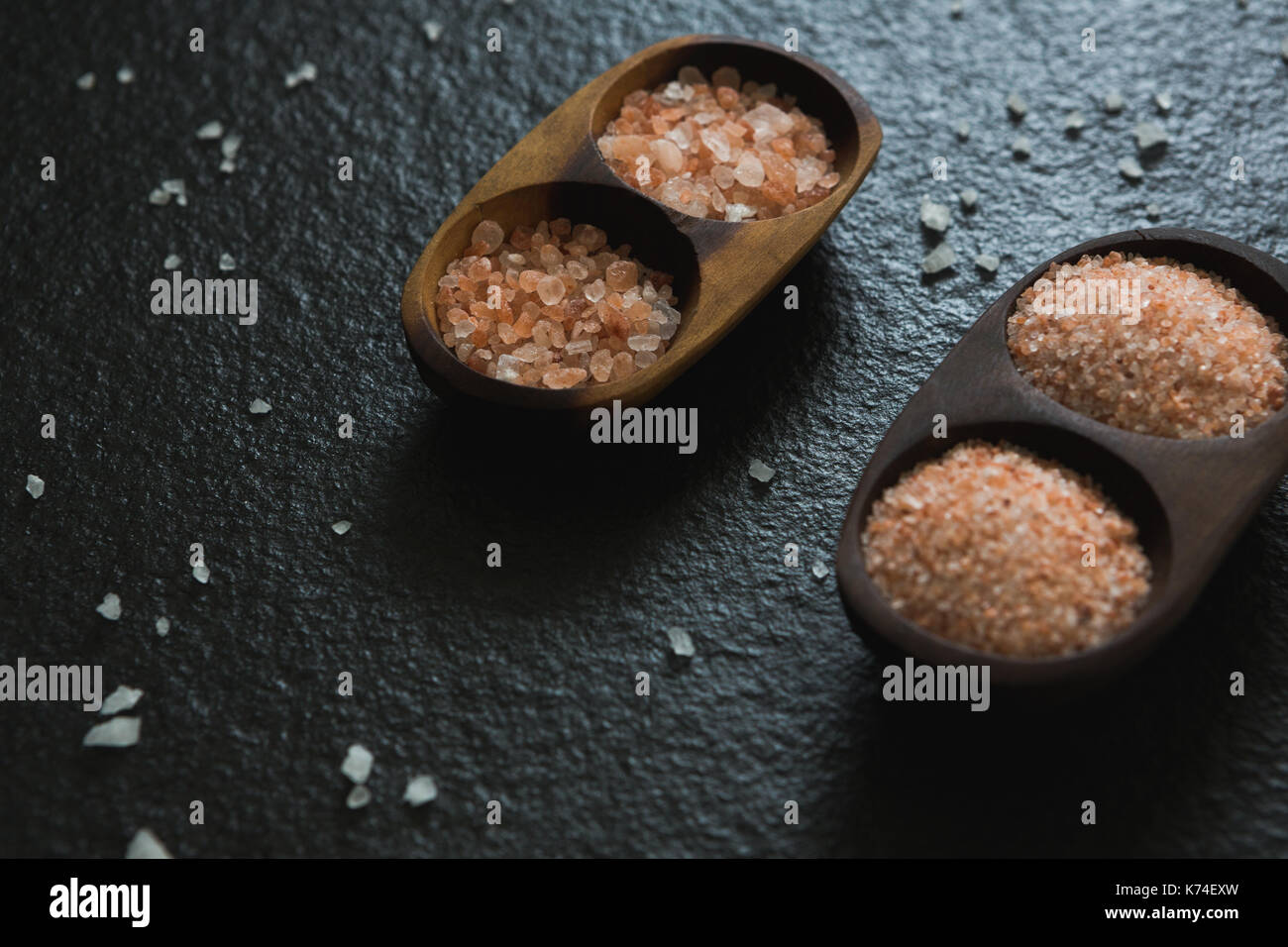 Sea salt in a tray on black background Stock Photo - Alamy