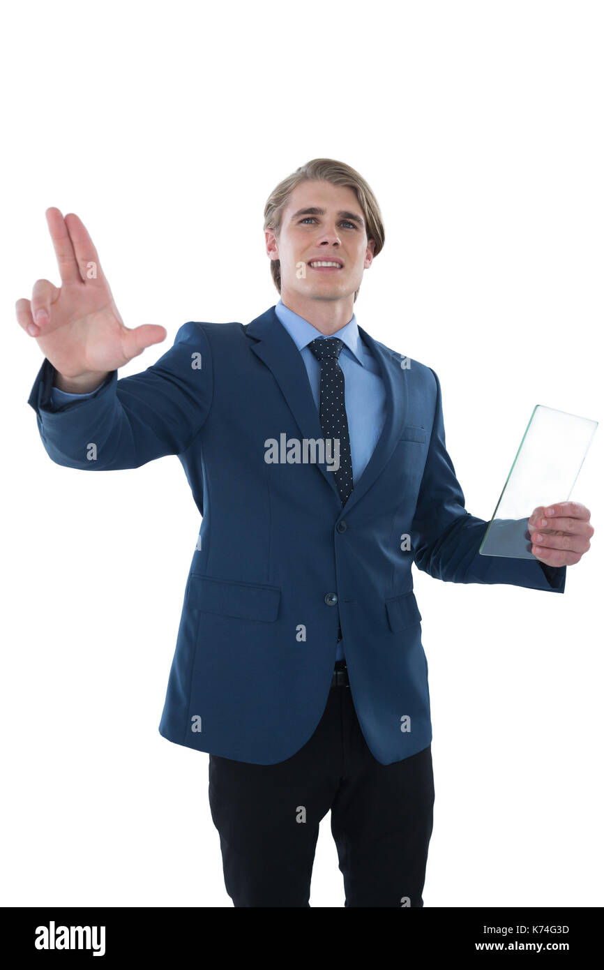Young businessman holding glass interface while touching imaginary screen against white background Stock Photo