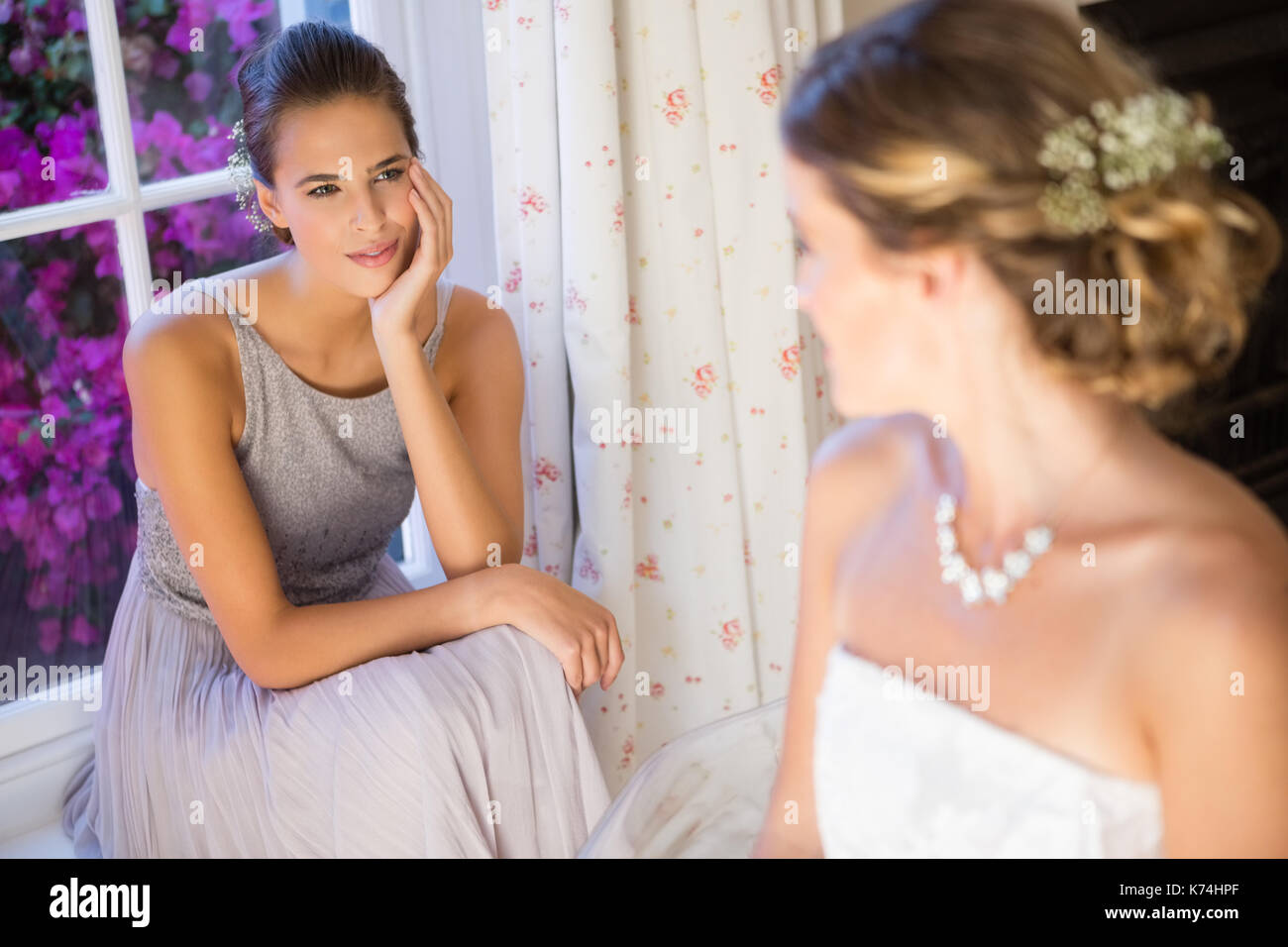 Bride talking to bridesmaid while sitting at home Stock Photo