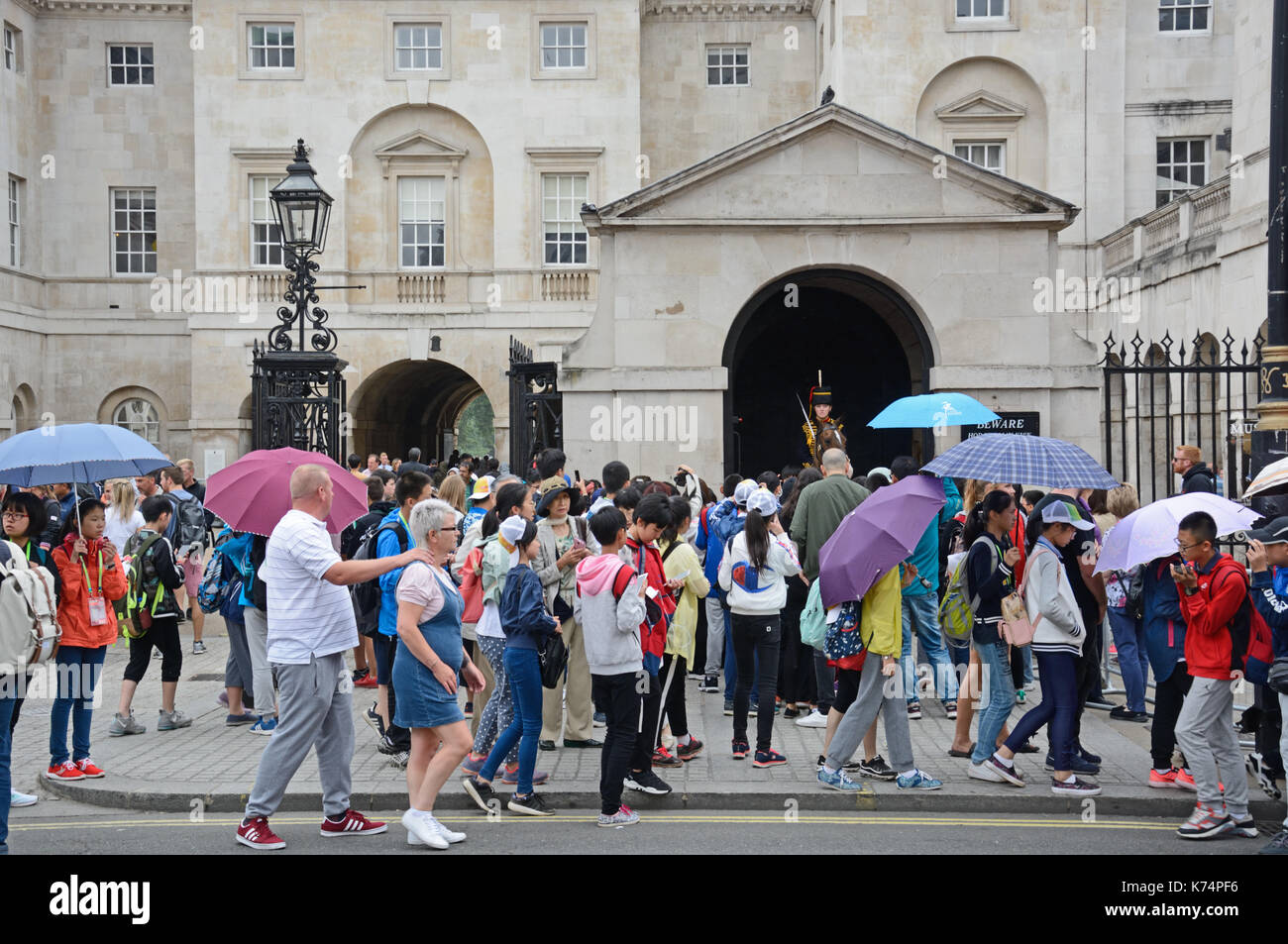 Many tourists, passing horse guards, on Whitehall, London Stock Photo