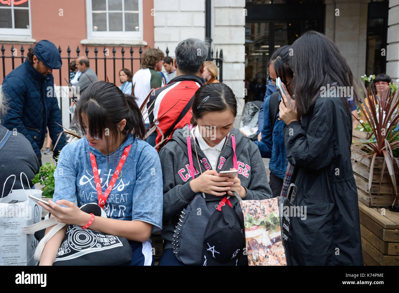 Tourists on mobile phones, London. Stock Photo