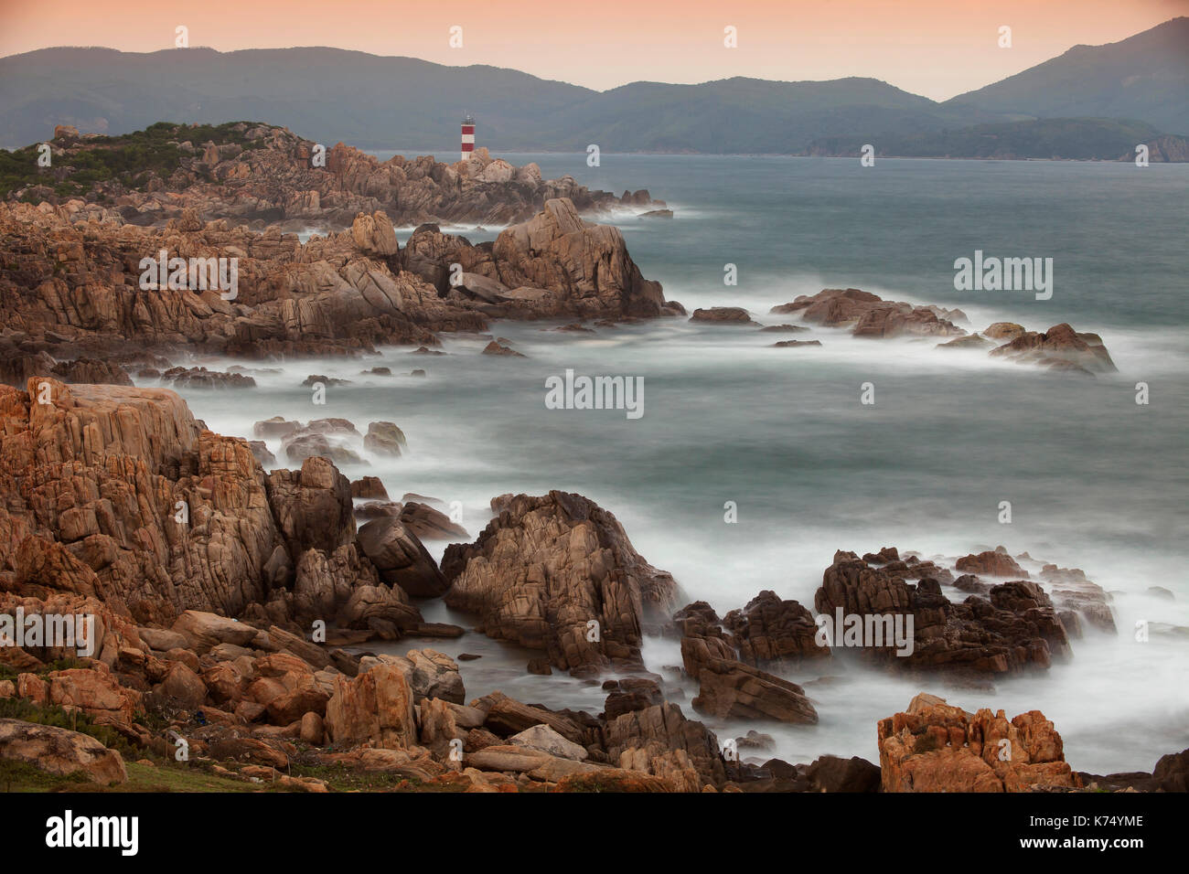 Rocky coast with lighthouse at Ganh Dia, Phu Yen Province, Vietnam Stock Photo